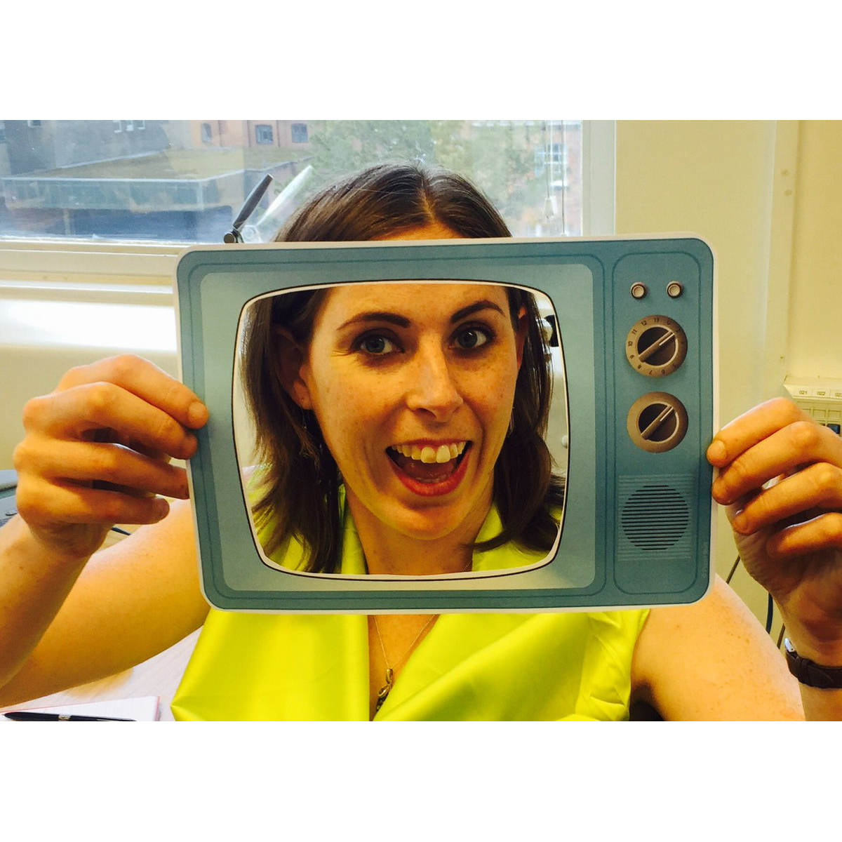 Rowena smiling while holding an image frame